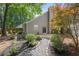 Exterior view of backyard with stone path, mulch beds, trees and patio, offering a serene outdoor space at 1901 Brittania Cir, Woodstock, GA 30188