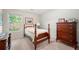 Cozy bedroom with a four-poster bed, wood dresser, neutral carpet and window overlooking backyard at 1901 Brittania Cir, Woodstock, GA 30188