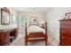 Cozy bedroom featuring a four-poster bed, wood dresser, and neutral carpet with plenty of natural light at 1901 Brittania Cir, Woodstock, GA 30188