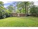 Expansive backyard with brick home, mature trees, and lush green grass at 1971 Hooper St, Decatur, GA 30032