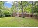 Large backyard with brick home, mature trees, and privacy fence at 1971 Hooper St, Decatur, GA 30032