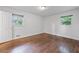 A bright bedroom with hardwood floors and two windows that allow for natural light at 1971 Hooper St, Decatur, GA 30032