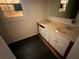 Bathroom with dark floors, white vanity with double sinks, and a window with natural light at 29 Ivy St, Porterdale, GA 30014