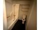 Cozy bathroom featuring a tub and shower combination with black floors and a simple shelf at 29 Ivy St, Porterdale, GA 30014