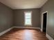 Bedroom featuring hardwood floors, a neutral color scheme, and a window overlooking the yard at 29 Ivy St, Porterdale, GA 30014