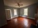Light-filled living room featuring hardwood floors, a ceiling fan, and a classic fireplace at 29 Ivy St, Porterdale, GA 30014