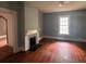 Living room with wood floors, neutral paint, a fireplace, and natural light from the large window at 29 Ivy St, Porterdale, GA 30014
