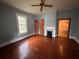 Spacious living room with original hardwood floors, fireplace, and ceiling fan at 29 Ivy St, Porterdale, GA 30014