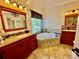 Luxurious bathroom with double vanity sinks, a soaking tub, tiled floors, and modern lighting fixtures at 4265 Lansmoore Xing, Suwanee, GA 30024