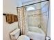 Cozy bathroom features a tub with tiled walls, shower curtain, and a window for natural light at 4265 Lansmoore Xing, Suwanee, GA 30024