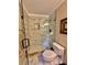 Modern bathroom features a glass-enclosed shower with marble-look tiles, a niche, and updated fixtures at 4265 Lansmoore Xing, Suwanee, GA 30024