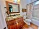Bathroom showcasing a granite countertop vanity, tub with patterned shower curtain, and wood-look floors at 4265 Lansmoore Xing, Suwanee, GA 30024