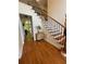 Bright foyer featuring hardwood floors, staircase with iron railings, and natural light streaming through the doorway at 4265 Lansmoore Xing, Suwanee, GA 30024