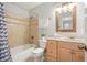 Bathroom featuring a shower-tub, wooden vanity, and framed mirror at 4977 Meadow Ln, Marietta, GA 30068