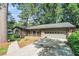 Beautiful home exterior featuring a well-kept lawn, mature trees, and a paved driveway at 1260 Fork Creek Trl, Decatur, GA 30033