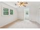 Well-lit bedroom with neutral carpet, windows, and a ceiling fan providing comfort at 1420 Pilgrim Rd, Cumming, GA 30040