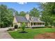 Charming home featuring a welcoming front porch, lush landscaping, and attached garage at 1420 Pilgrim Rd, Cumming, GA 30040