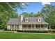 Beautiful home with a covered front porch and manicured lawn, set against a backdrop of mature trees at 1420 Pilgrim Rd, Cumming, GA 30040