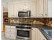 Kitchen with stainless oven, granite countertops, plentiful cabinets, and tile backsplash at 1420 Pilgrim Rd, Cumming, GA 30040