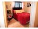 A bedroom with simple decor, a soft pink rug, and a red bedspread, offering a cozy retreat at 636 North Ave # 11E, Jonesboro, GA 30236
