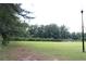 Open green field featuring mature trees and a lamp post; a peaceful community spot at 636 North Ave # 11E, Jonesboro, GA 30236
