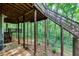 Backyard featuring lower patio and stairs to upper decks, backing to the woods at 115 Township Ct, Woodstock, GA 30189