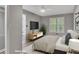 Bedroom features a wall-mounted TV, lots of light, and comfortable furnishing at 115 Township Ct, Woodstock, GA 30189