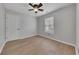 Bright bedroom features wood-look flooring, a ceiling fan, and a large window at 115 Township Ct, Woodstock, GA 30189