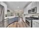 Bright kitchen with stainless steel appliances, white cabinets, gray island, and hardwood floors at 115 Township Ct, Woodstock, GA 30189