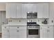 Close up of white cabinets, stainless steel appliances, and white countertops in a well-lit kitchen at 115 Township Ct, Woodstock, GA 30189