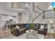 Spacious living room with a large sectional sofa, hardwood floors, staircase, and modern decor at 115 Township Ct, Woodstock, GA 30189