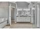 Bright main bathroom with dual vanities, granite countertops, separate tub and glass shower at 115 Township Ct, Woodstock, GA 30189