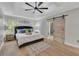 Relaxing main bedroom with a large bed, modern ceiling fan, wood floors, and a sliding barn door at 115 Township Ct, Woodstock, GA 30189