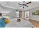 Bright main bedroom featuring a king-sized bed, stylish decor, and a view into the ensuite bath at 115 Township Ct, Woodstock, GA 30189