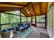 Relaxing screened-in patio with wood ceiling features wicker seating, ceiling fan, and a TV at 115 Township Ct, Woodstock, GA 30189