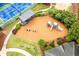 Overhead view of the playground with wood chip base, swings, and slides, with tennis courts nearby at 115 Township Ct, Woodstock, GA 30189