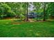 Spacious backyard featuring a lush lawn, mature trees, and a modern home at 1510 Chevron Dr, Sandy Springs, GA 30350
