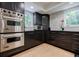 Modern kitchen featuring stainless steel appliances, dark cabinetry, and a tile backsplash at 1510 Chevron Dr, Sandy Springs, GA 30350