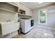 Functional laundry room with modern washer and dryer, ample cabinets, and a utility sink at 1510 Chevron Dr, Sandy Springs, GA 30350
