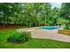 Inviting backyard pool with pristine landscaping, surrounded by mature trees, and a diving board at 1510 Chevron Dr, Sandy Springs, GA 30350