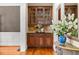 Charming bar area features custom cabinetry, granite countertop, and glass shelves for displaying glassware at 2953 Kings Walk Ave, Marietta, GA 30062