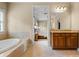 Bathroom with tub, vanity with granite countertops, and view into the main bedroom at 2953 Kings Walk Ave, Marietta, GA 30062