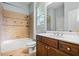 Well-lit bathroom with tiled shower and tub combination, vanity with sink, and neutral decor at 2953 Kings Walk Ave, Marietta, GA 30062