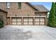 Three-car garage with neutral-toned doors and carriage accents providing ample parking and curb appeal at 2953 Kings Walk Ave, Marietta, GA 30062