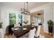 Elegant dining room setup with a dark wood table, upholstered chairs, and a modern chandelier at 387 Hillside Sw Dr, Atlanta, GA 30310