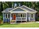 Charming blue home with a welcoming front porch and an orange front door nestled among lush trees at 387 Hillside Sw Dr, Atlanta, GA 30310