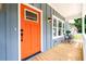 Inviting front porch with a bright orange door, wooden flooring, and a cozy seating area at 387 Hillside Sw Dr, Atlanta, GA 30310