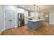 Well-lit kitchen featuring white cabinets, stainless steel appliances, and gray island, offering style and functionality at 387 Hillside Sw Dr, Atlanta, GA 30310