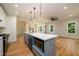 Open concept kitchen with gray island, stainless steel appliances, and modern lighting, ideal for entertaining at 387 Hillside Sw Dr, Atlanta, GA 30310