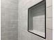 Shower featuring a recessed niche, providing convenient storage space, set against a backdrop of light gray subway tiles at 387 Hillside Sw Dr, Atlanta, GA 30310